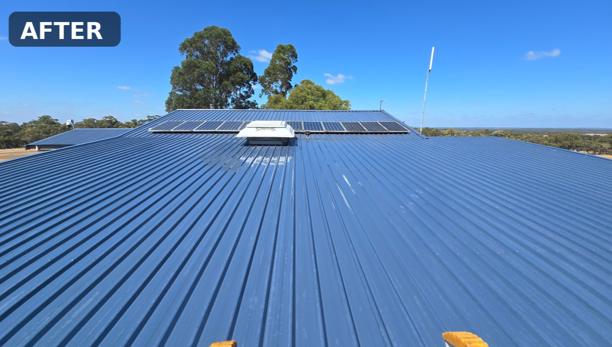 Photo of a blue metal roof with solar panels installed and a sky with some clouds in the background.